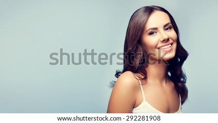 Portrait of beautiful happy smiling young brunette woman, with blank copyspace area for text or slogan