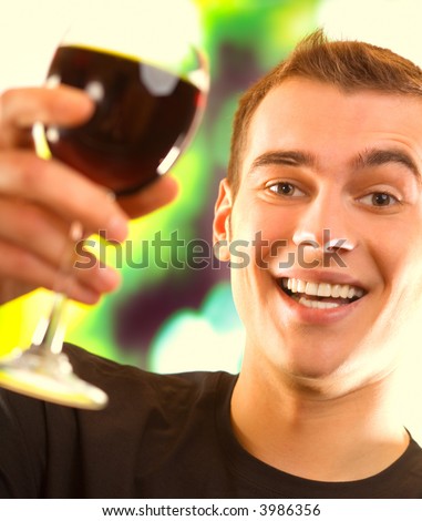 Young happy smiling man with red wine glass toasting