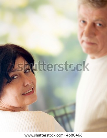 Senior attractive happy couple walking together outdoors. Focus on woman. You can use left part as copyspace.