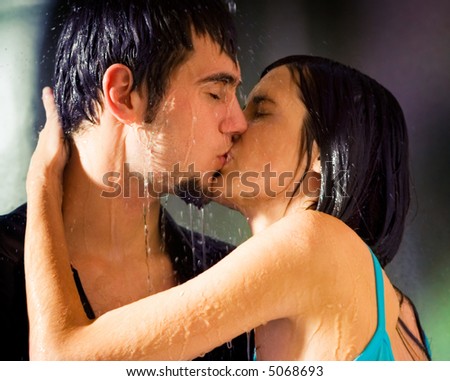young couple kissing in rain. stock photo : Young hugging couple kissing under a rain, in passion