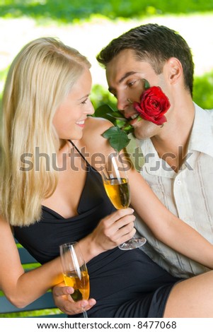 Funny young happy couple with gift and rosa, outdoors