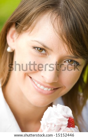 Portrait of young happy smiling woman with cake outdoors
