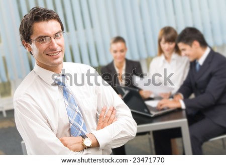 Portrait of successful businessman and business team at office meeting