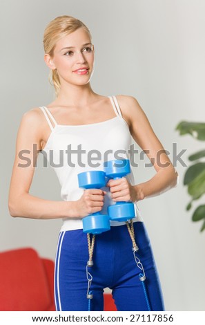 Woman doing fitness exercises with growth and dumbbells at home