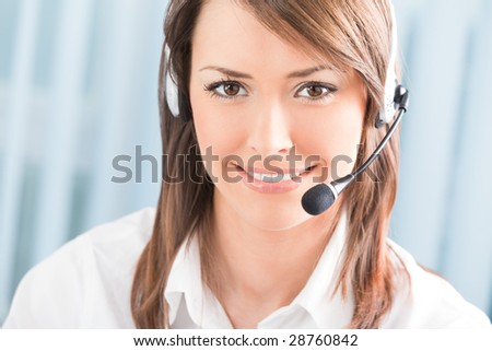 Portrait of happy support phone operator in headset at workplace