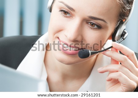 Support phone operator in headset with computer at workplace