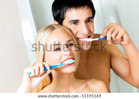 Young couple cleaning teeth together at bathroom