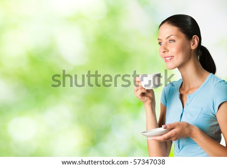 Young happy smiling woman drinking coffee, outdoors. You can use left part for slogan, big text or banner.