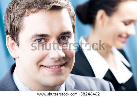 Portrait of successful businessman and colleague on background, at office