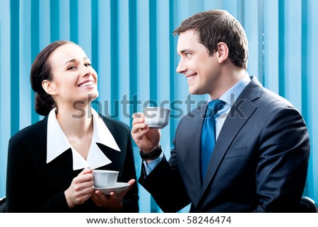 Two happy businesspeople with coffee at office