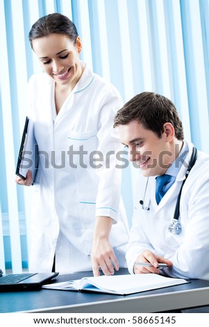 Two happy medical people working together at office