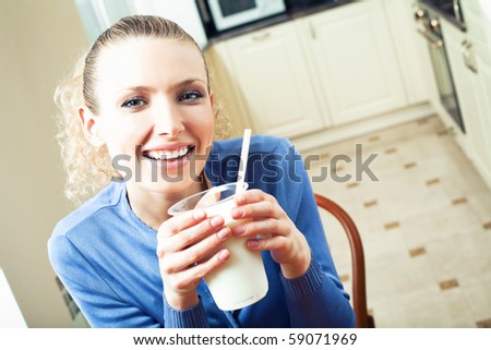 Portrait of young woman drinking milk at home