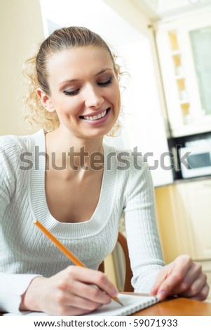Young woman with notebook or organizer at home