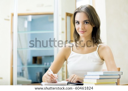 Young woman with organizer and books at home