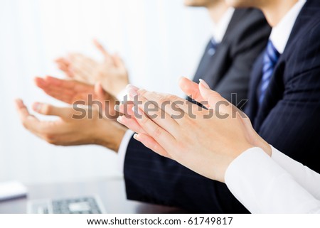 Close up clapping hands of businesspeople at presentation, meeting, seminar or conference