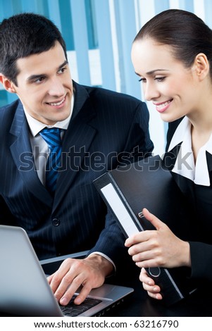 Two happy businesspeople working together at office