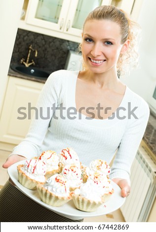 Portrait of beautiful smiling woman with cakes, indoors