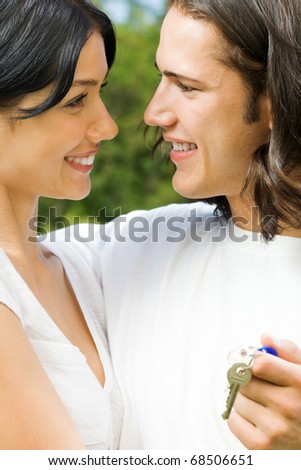 Young happy smiling couple with key, outdoor