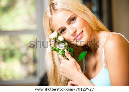 Portrait of young happy smiling woman with bouquet of white roses