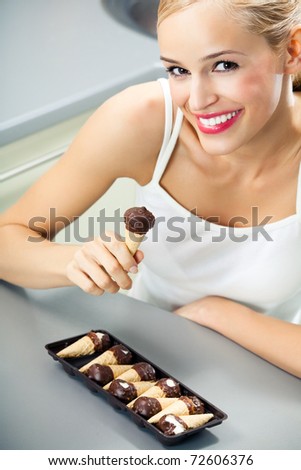 Portrait of young happy woman eating cakes at home