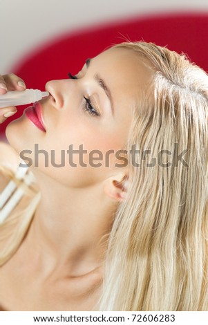 Young woman dripping nose at home