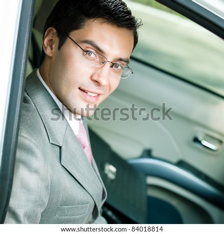 Portrait of young happy smiling businessman in the car