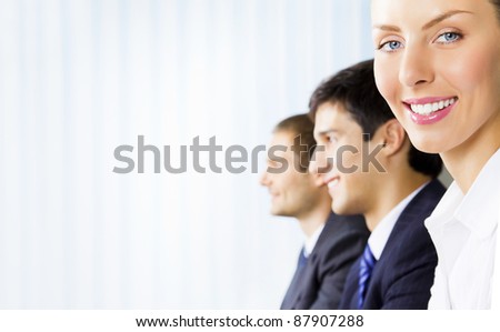 Three young happy successful businesspeople working at office, with copyspace