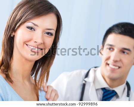 Portrait of happy smiling female patient and doctor at office. Focus on woman.