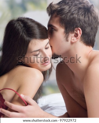 Young beautiful amorous couple making love in bed