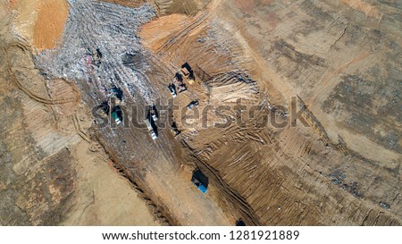 Aerial views of a county trash dump being serviced by multiple dump trucks