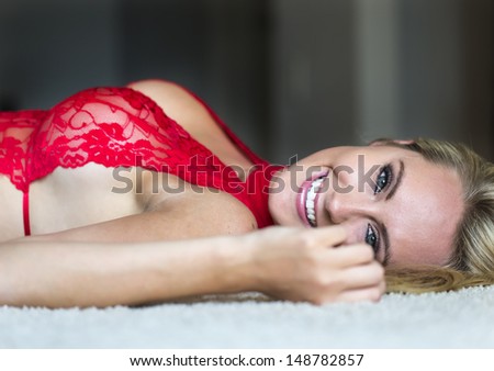 Blonde model posing in lingerie with natural lighting