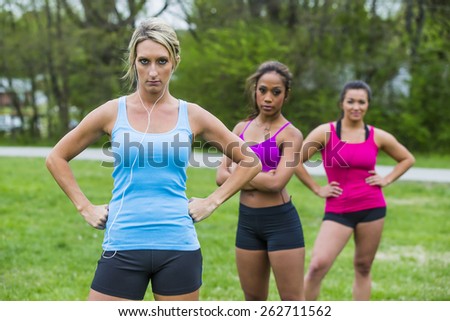 Three young women exercising at a local park