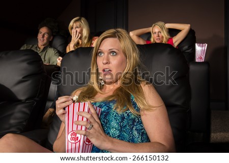 A group of people watching a movie showing emotion