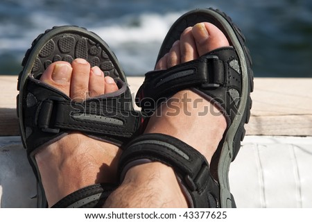 stock photo A pair of male feet on the stern of a boat with ocean
