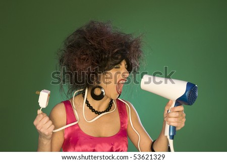 A brunette model has issues trying to plug in the power cord to finish her hair