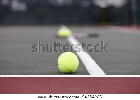 Tennis balls sitting on the ground at a tennis court