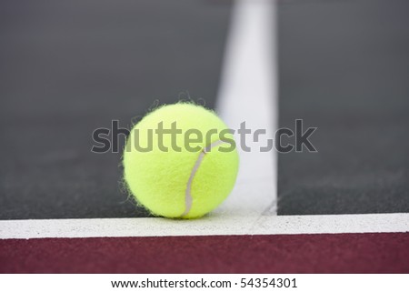 Tennis balls sitting on the ground at a tennis court