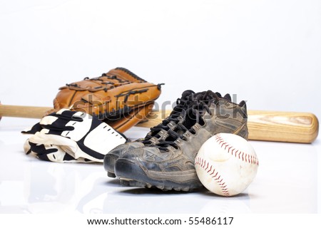 Used baseball cleats against a glove, softball, bat, and batting gloves on a white background