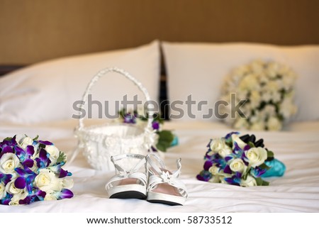 Bridal flowers and shoes on a white bed before a wedding