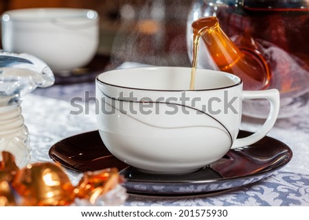 Black tea being poured into a cup