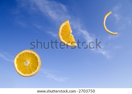 Orange slices at different stages of consumption on a blue sky background
