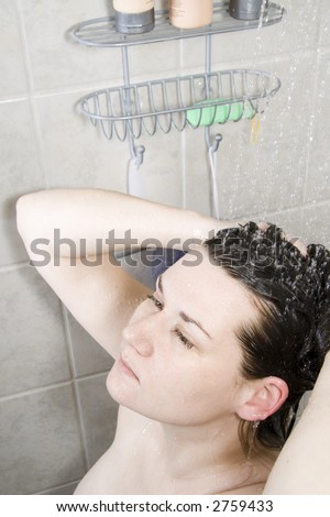 Young woman washes her hair in the shower