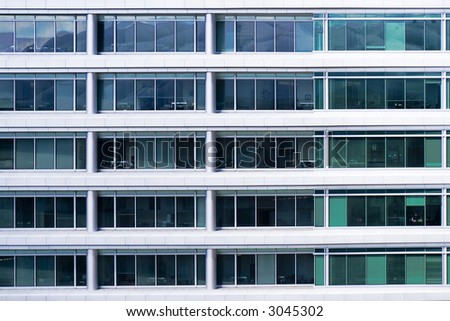Section of exterior of a modern office building with repetitive pattern of windows