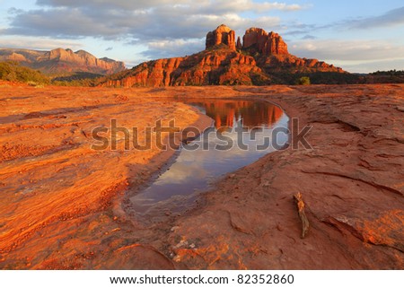 Cathedral Rock in the distance is reflected in a pool of water at sunset