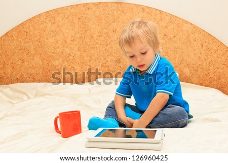 Little boy with touch pad at home