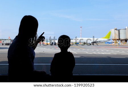 silhouettes of mother and baby in the airport