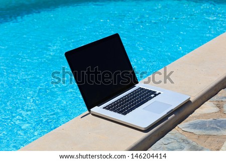 laptop at the pool, work on holiday concept