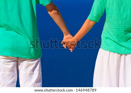 Close up of couple holding hands on sea vacation