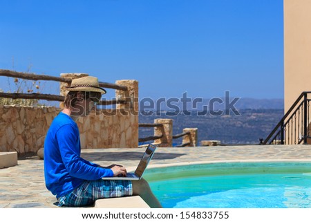 working on laptop at the pool, work on holiday concept