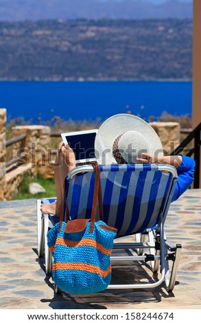 woman with touch pad on sea vacation by the pool